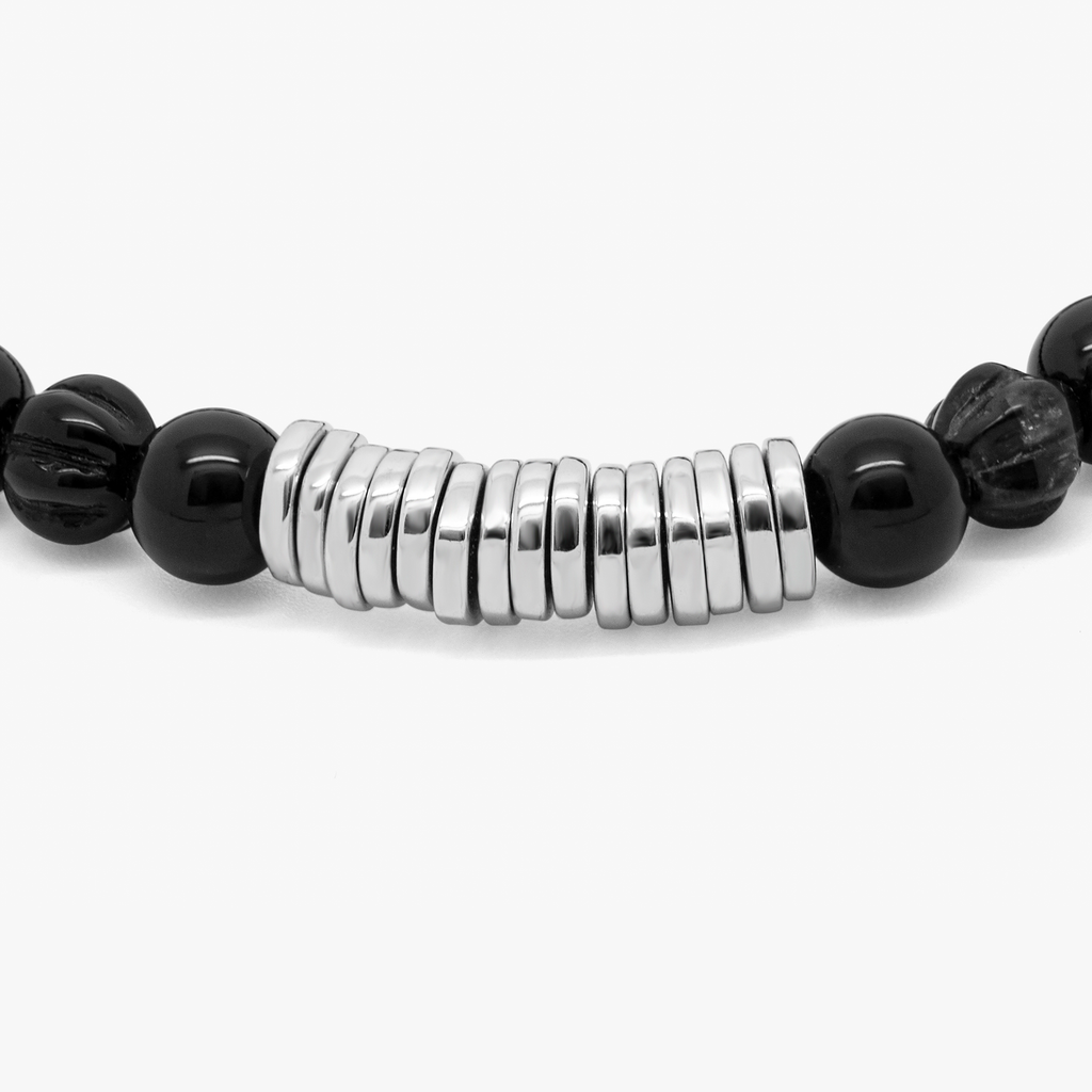 A rhodium-plated silver bracelet with black agate beads and silver discs.