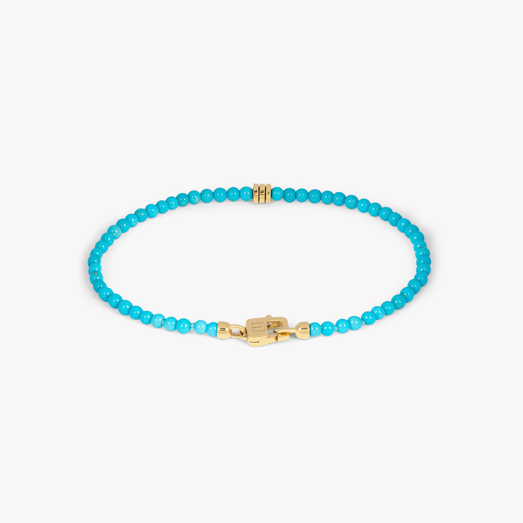 A turquoise bracelet with 18k gold discs and a gold lobster clasp. 