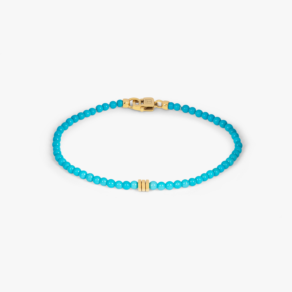 A turquoise bracelet with 18k gold discs and a gold lobster clasp. 