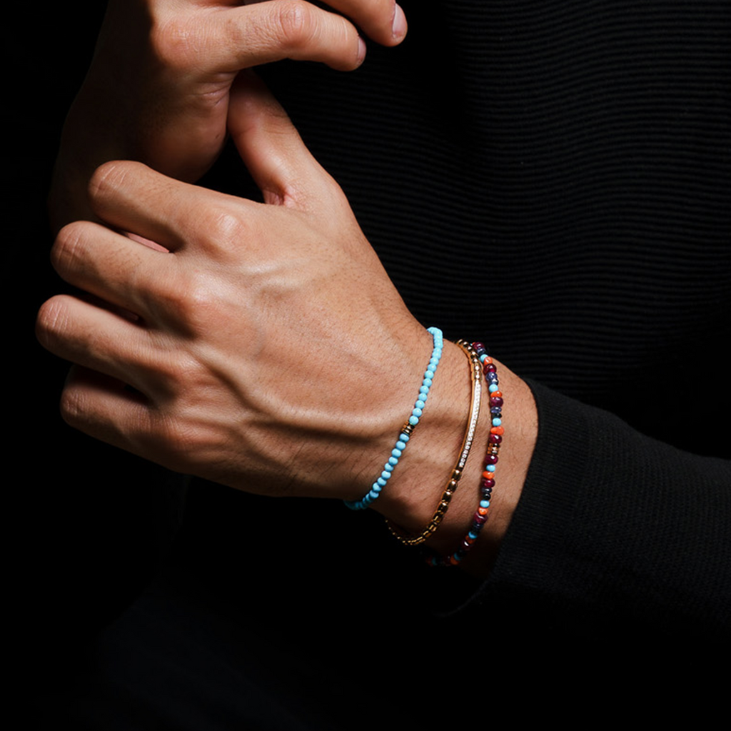 A turquoise bracelet with 18k gold discs and a gold lobster clasp. 