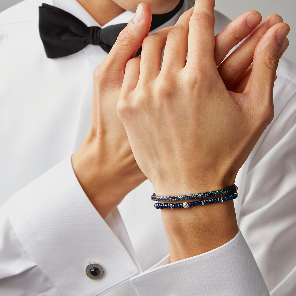 A rhodium-plated silver bracelet with blue sapphire beads and a lobster clasp.