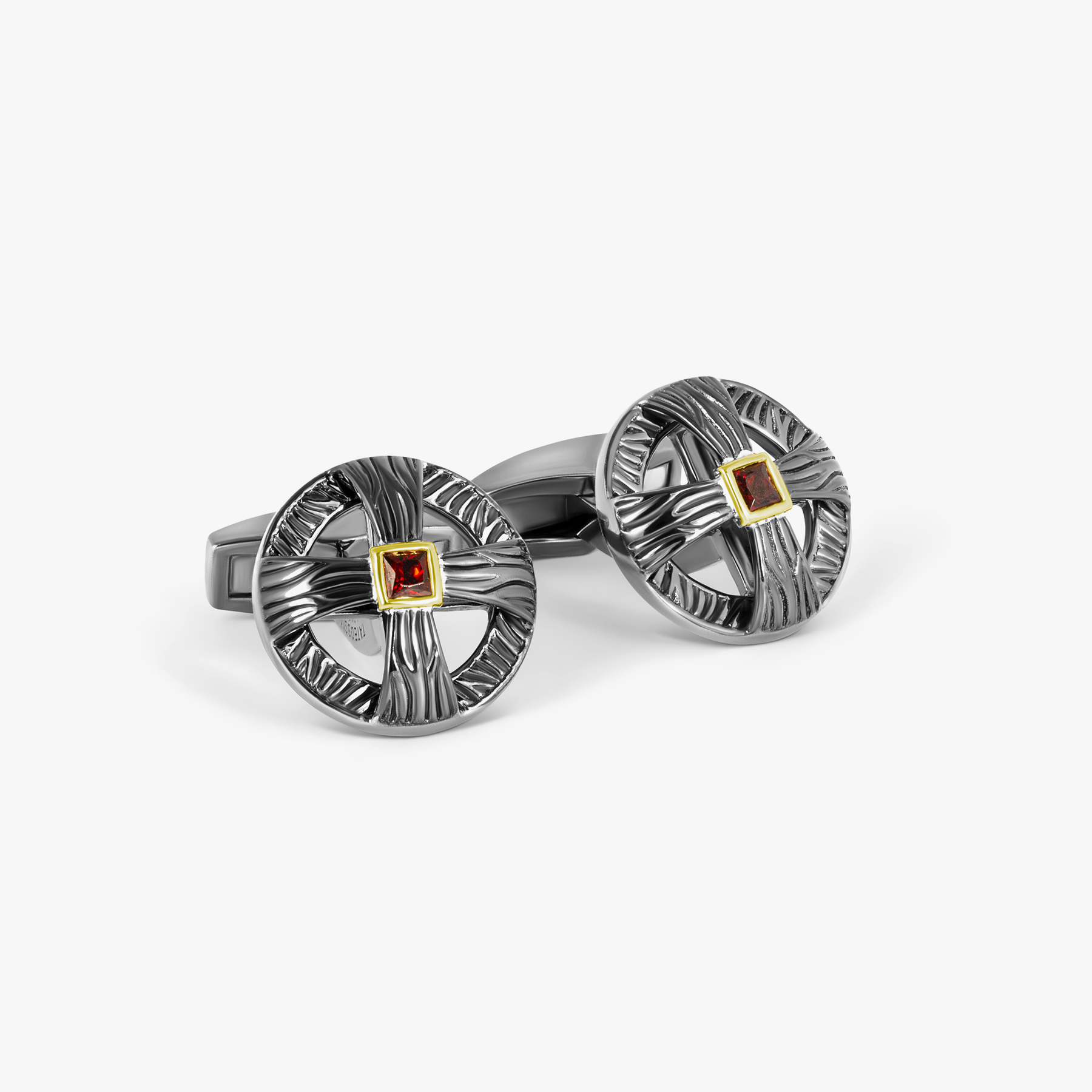 A pair of oxidised sterling silver cufflinks with red and silver colors and yellow gold plating on the garnet centers.