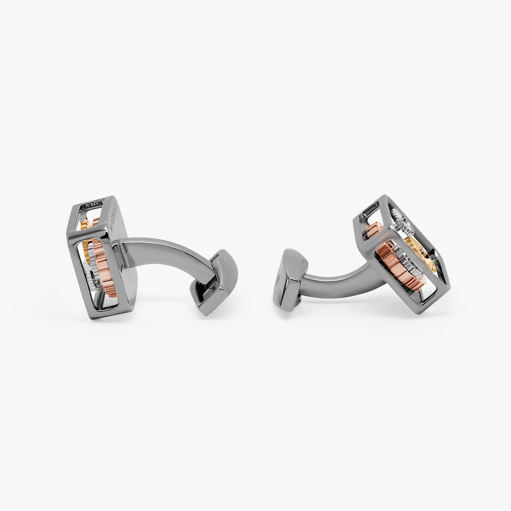 A pair of black gunmetal plated square gear cufflinks with visible mechanical gears inside the links.