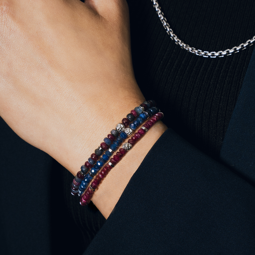 A rhodium-plated silver bracelet with blue sapphire beads and a lobster clasp.