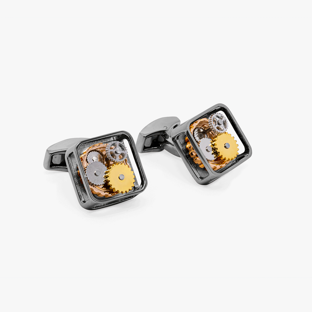 A pair of black gunmetal plated square gear cufflinks with visible mechanical gears inside the links.
