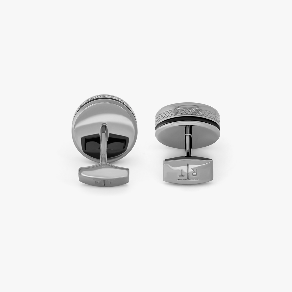 A pair of gunmetal cufflinks with black enamel and tourbillon gear detail.