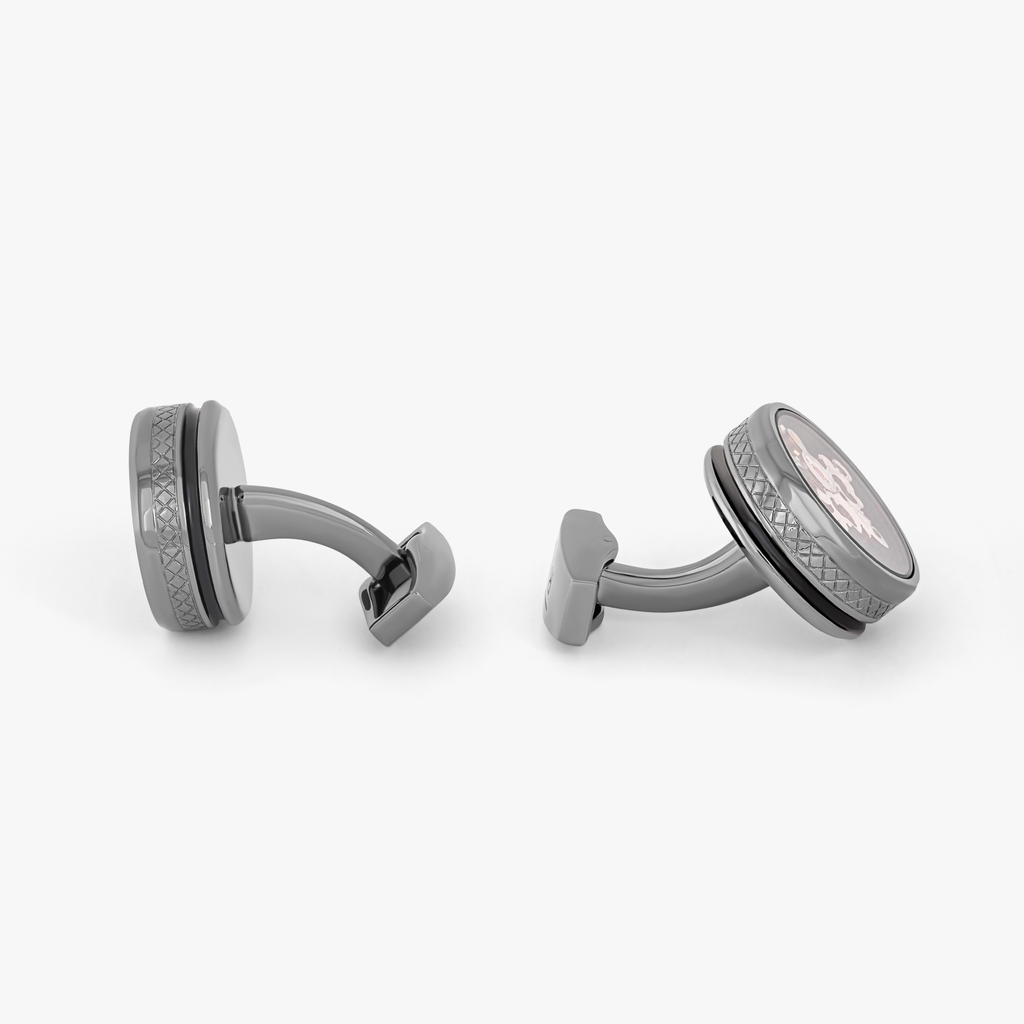 A pair of gunmetal cufflinks with black enamel and tourbillon gear detail.