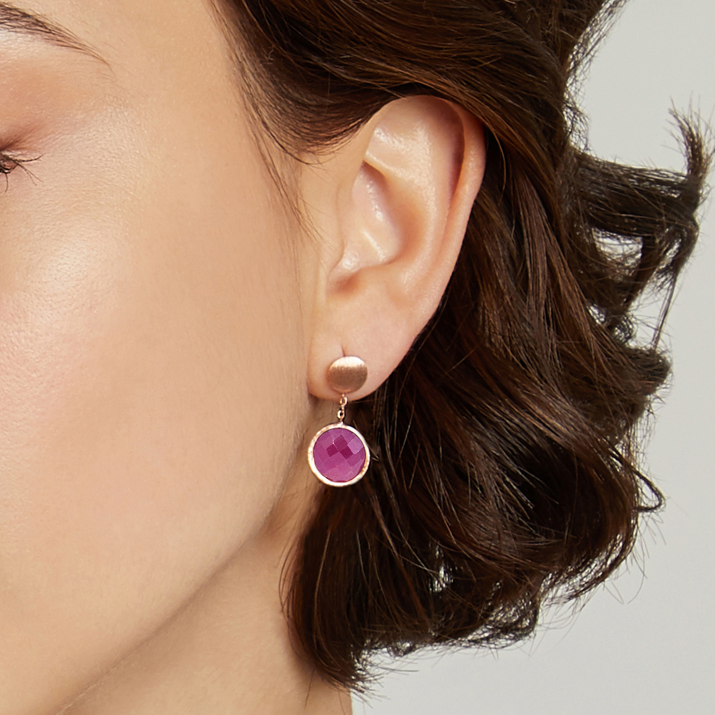 Woman wearing Kensington drop earrings in ruby root and 14k satin rose gold