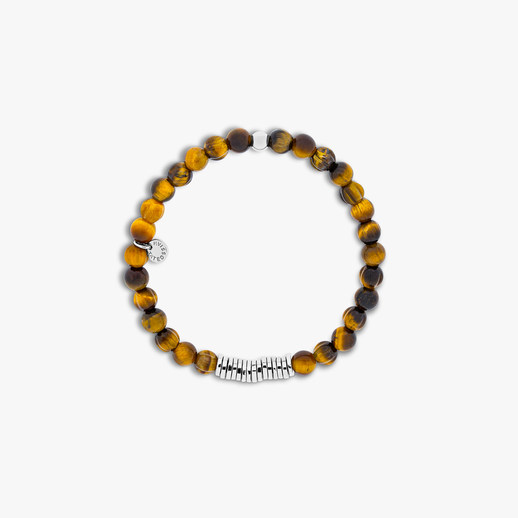 A rhodium-plated silver bracelet with brown tiger eye beads, featuring a closed elastic band and hand-carved semi-precious stones.