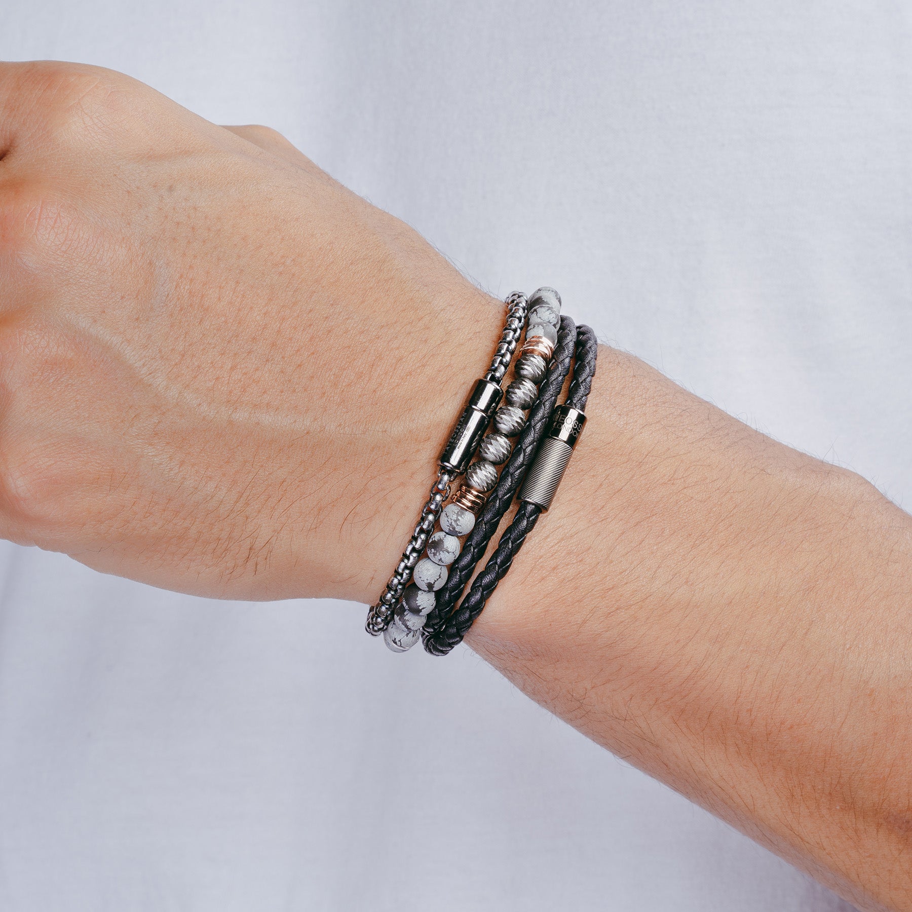 A black leather bracelet with a sterling silver clasp, double wrapped and intricately braided