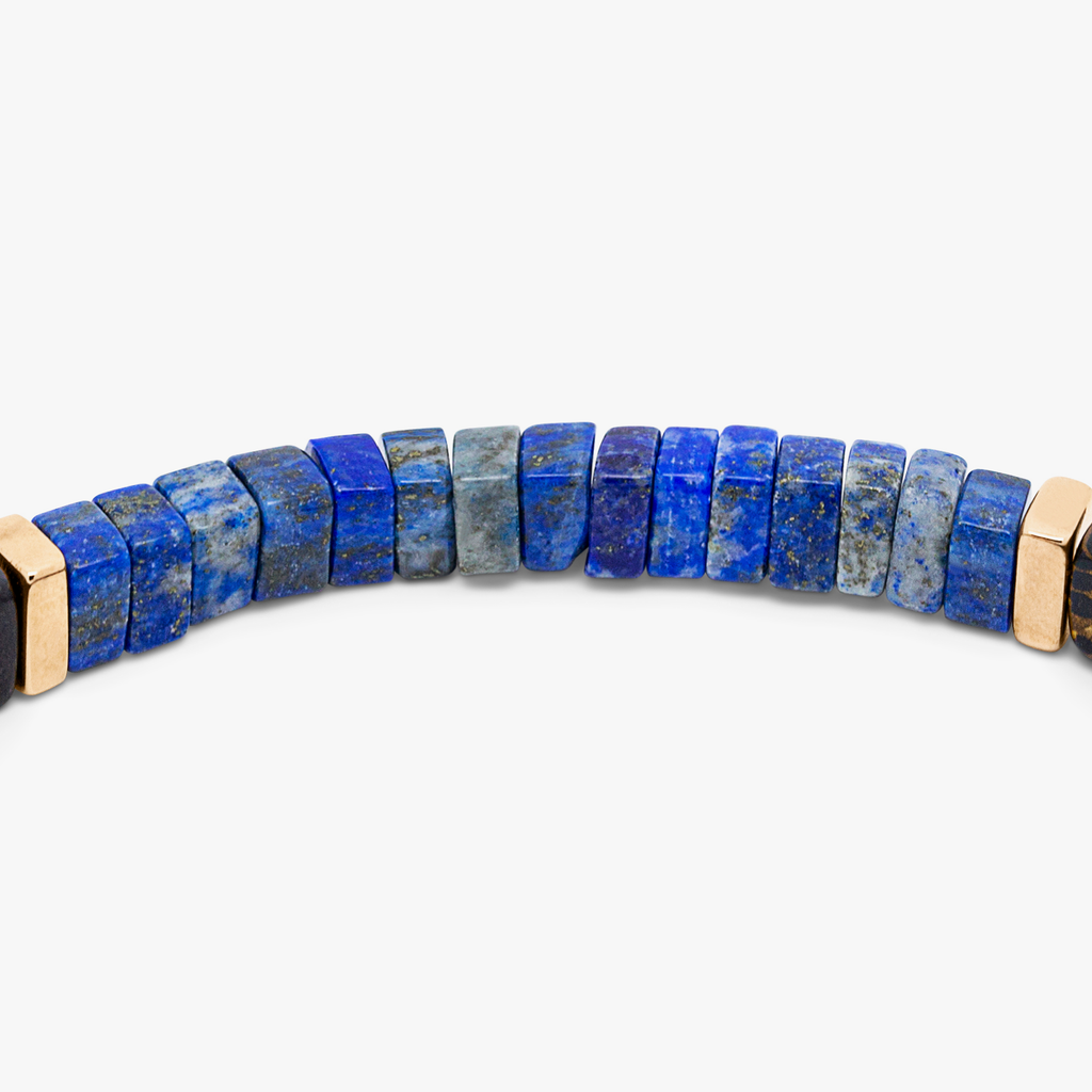 A bracelet with a combination of dark and light wood beads, accented by rose gold-colored sterling silver discs and a central lapis stone.