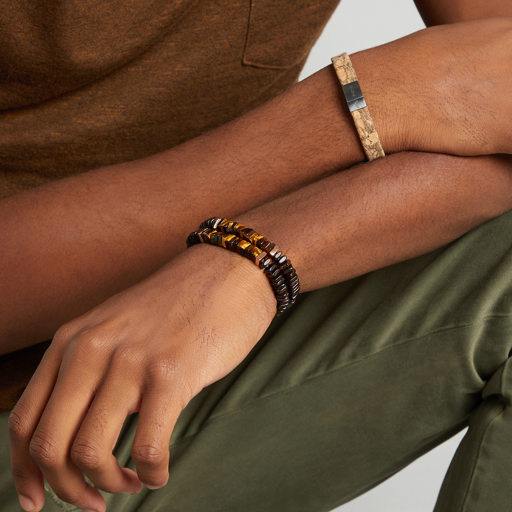A bracelet made of tiger eye, palm and ebony wood with rose gold plated sterling silver accents.