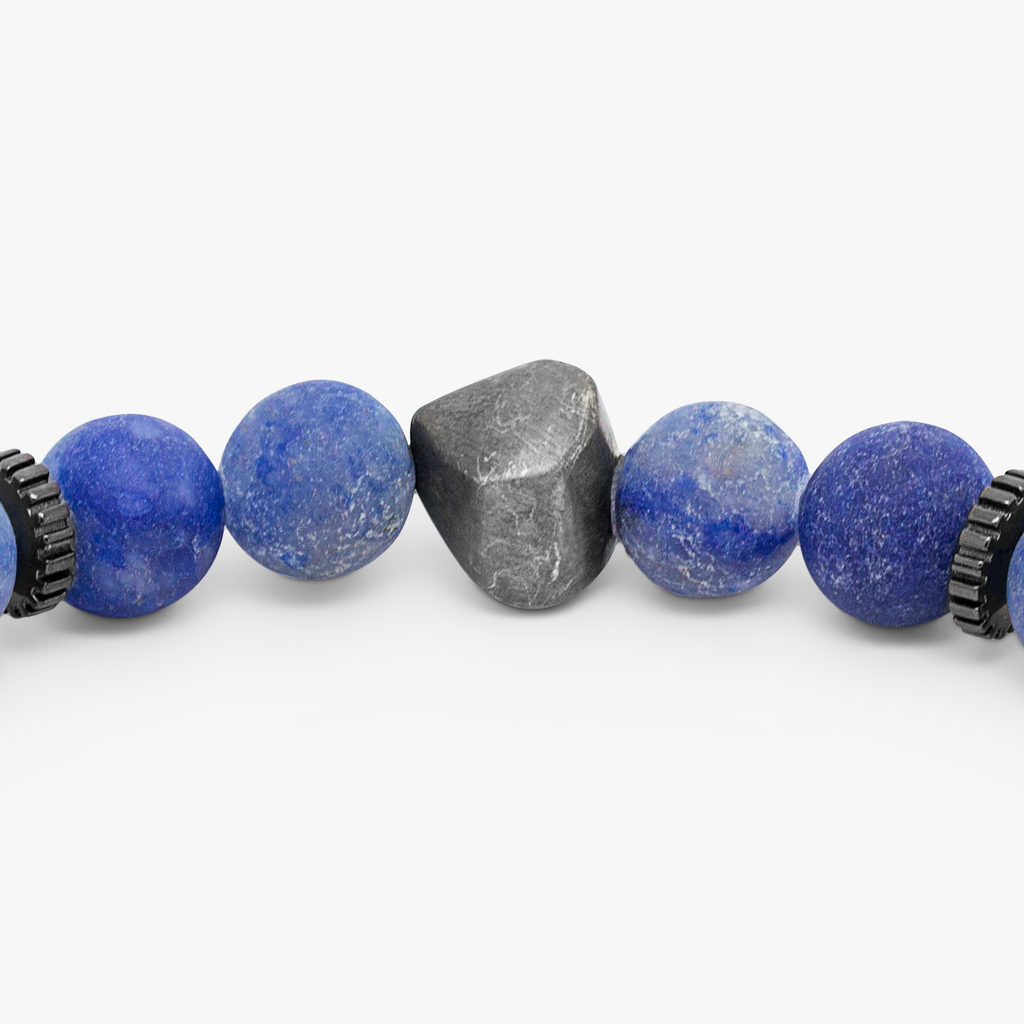 A bracelet with a mix of dark and light blue beads, some shaped like lava rocks, and black rhodium plated sterling silver detailing.