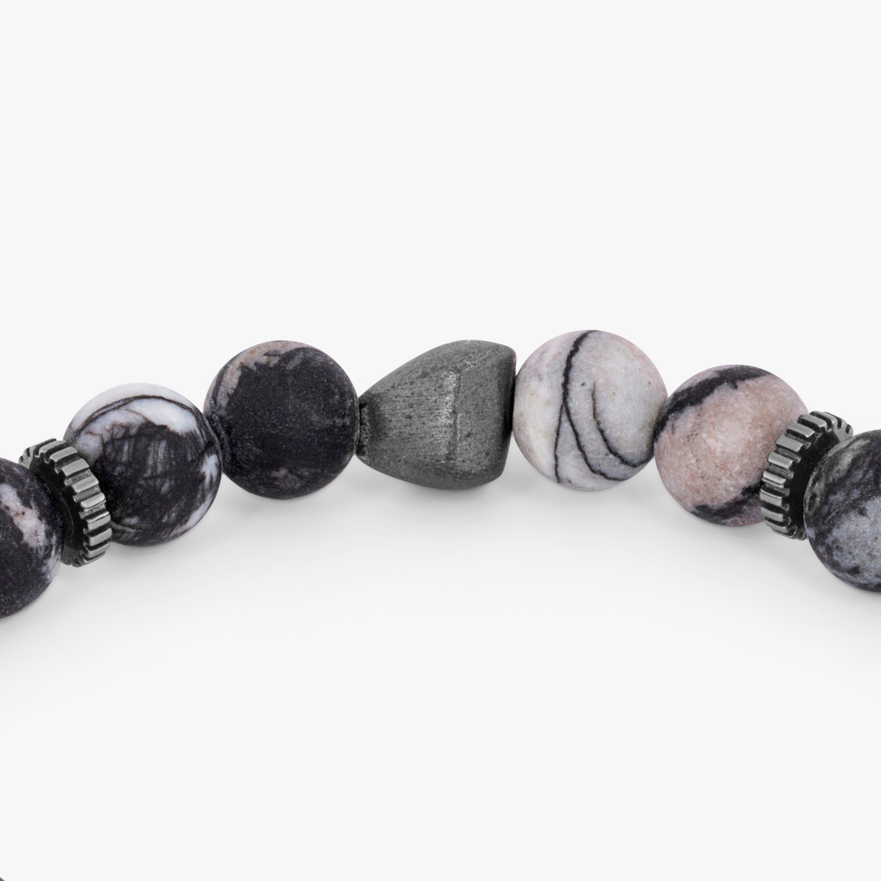 A bracelet with a combination of black and multicolored beads, possibly spiderweb jasper and raw volcanic lava beads, with black rhodium plated sterling silver detailing.