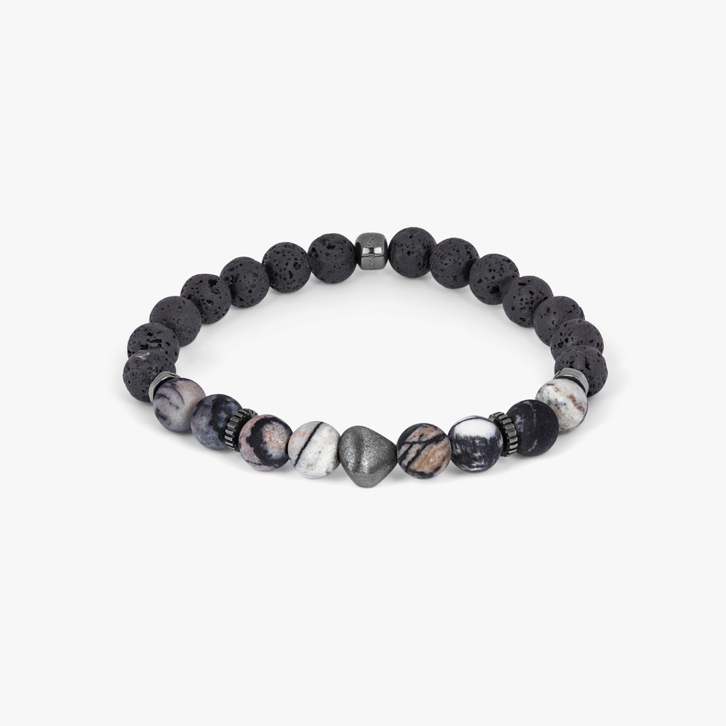 A bracelet with a combination of black and multicolored beads, possibly spiderweb jasper and raw volcanic lava beads, with black rhodium plated sterling silver detailing.