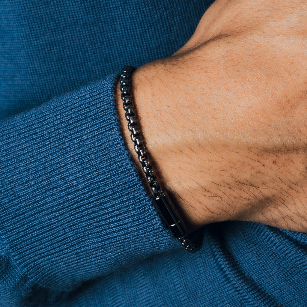 A black ruthenium plated silver box chain bracelet with a pop clasp closure.