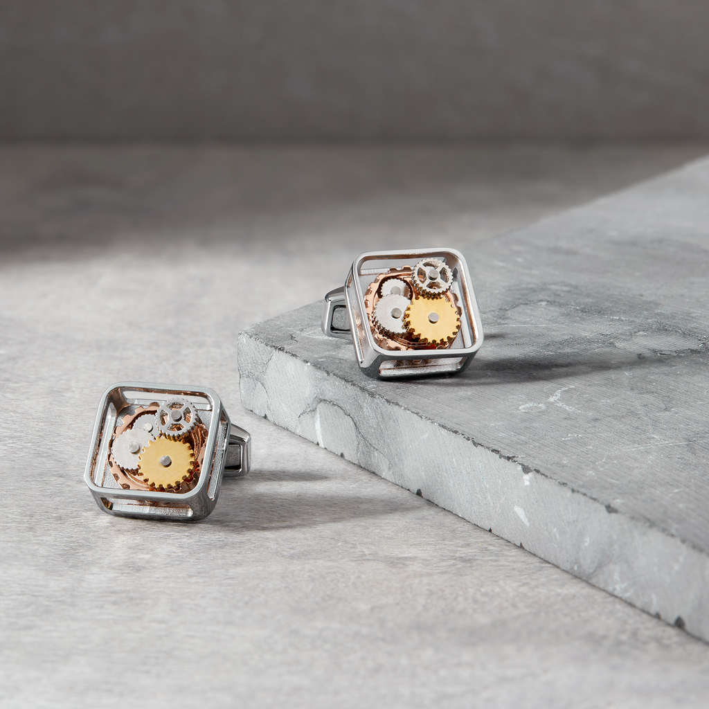 A pair of silver square gear cufflinks with palladium plating and visible mechanical gears inside.