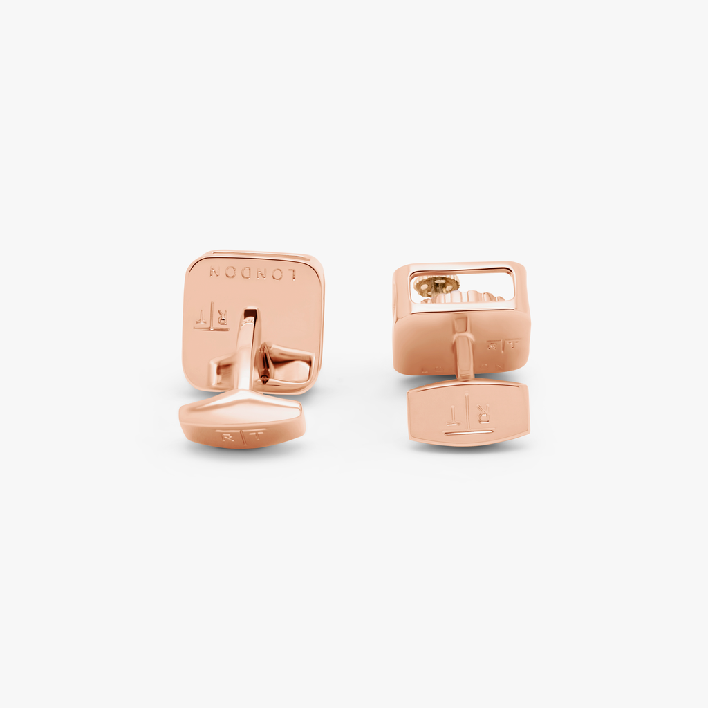 A pair of rose gold-plated square gear cufflinks with visible mechanical gears inside.