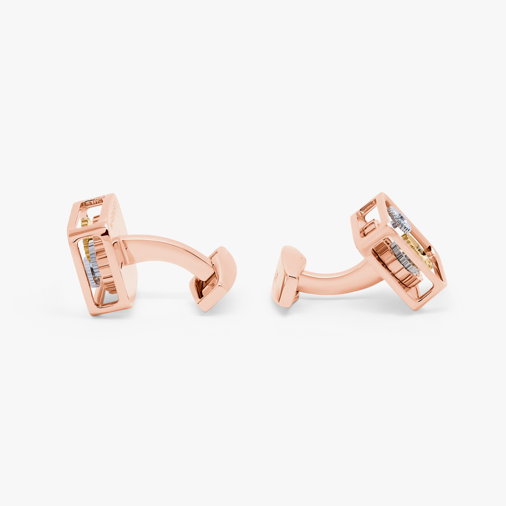 A pair of rose gold-plated square gear cufflinks with visible mechanical gears inside.