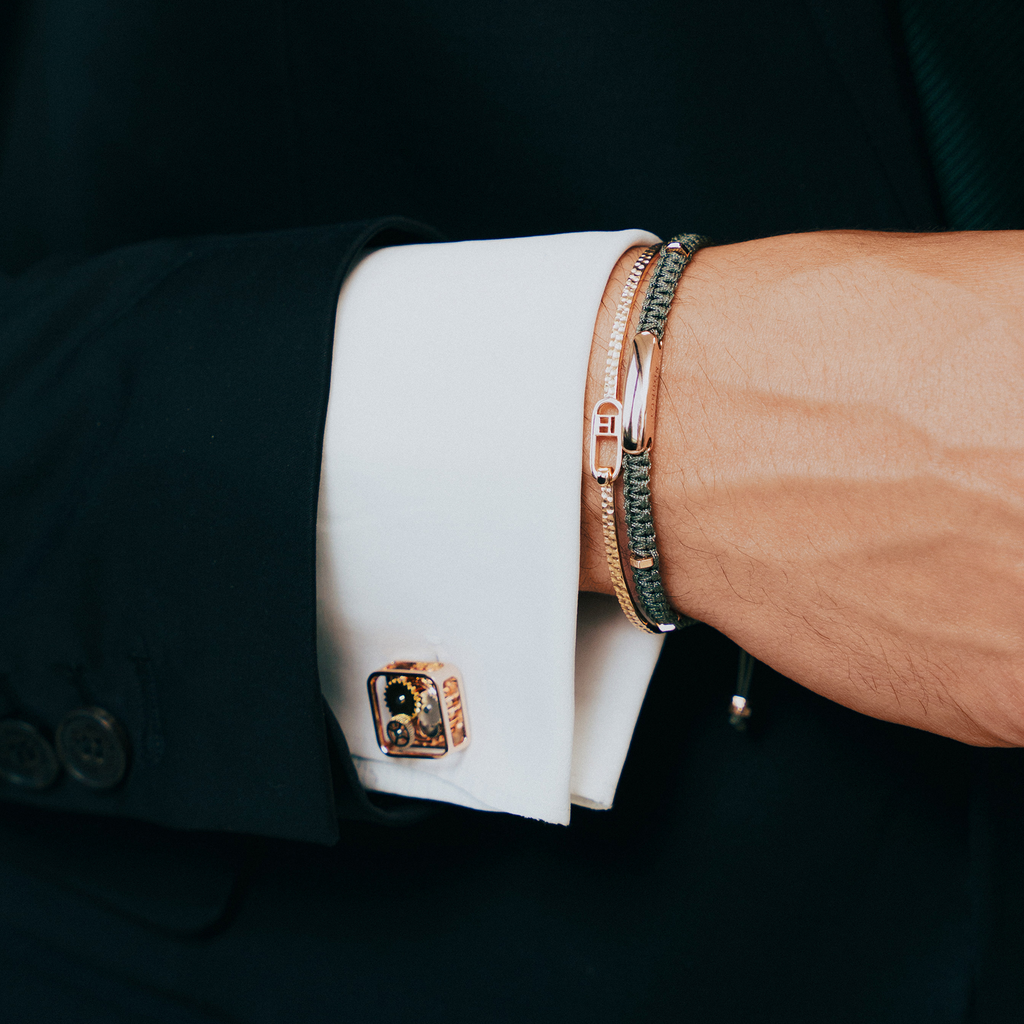 A pair of rose gold-plated square gear cufflinks with visible mechanical gears inside.
