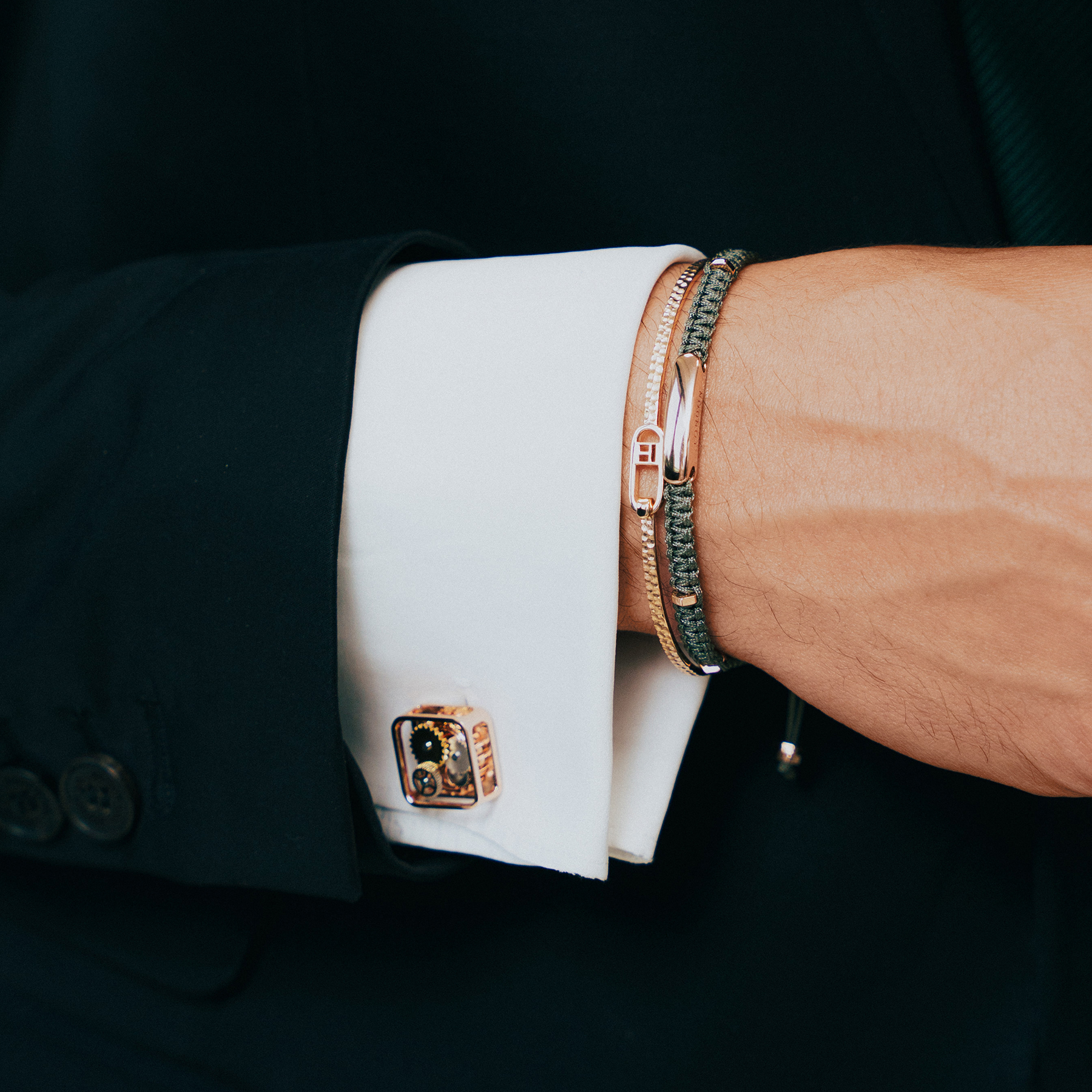 A pair of rose gold-plated square gear cufflinks with visible mechanical gears inside.