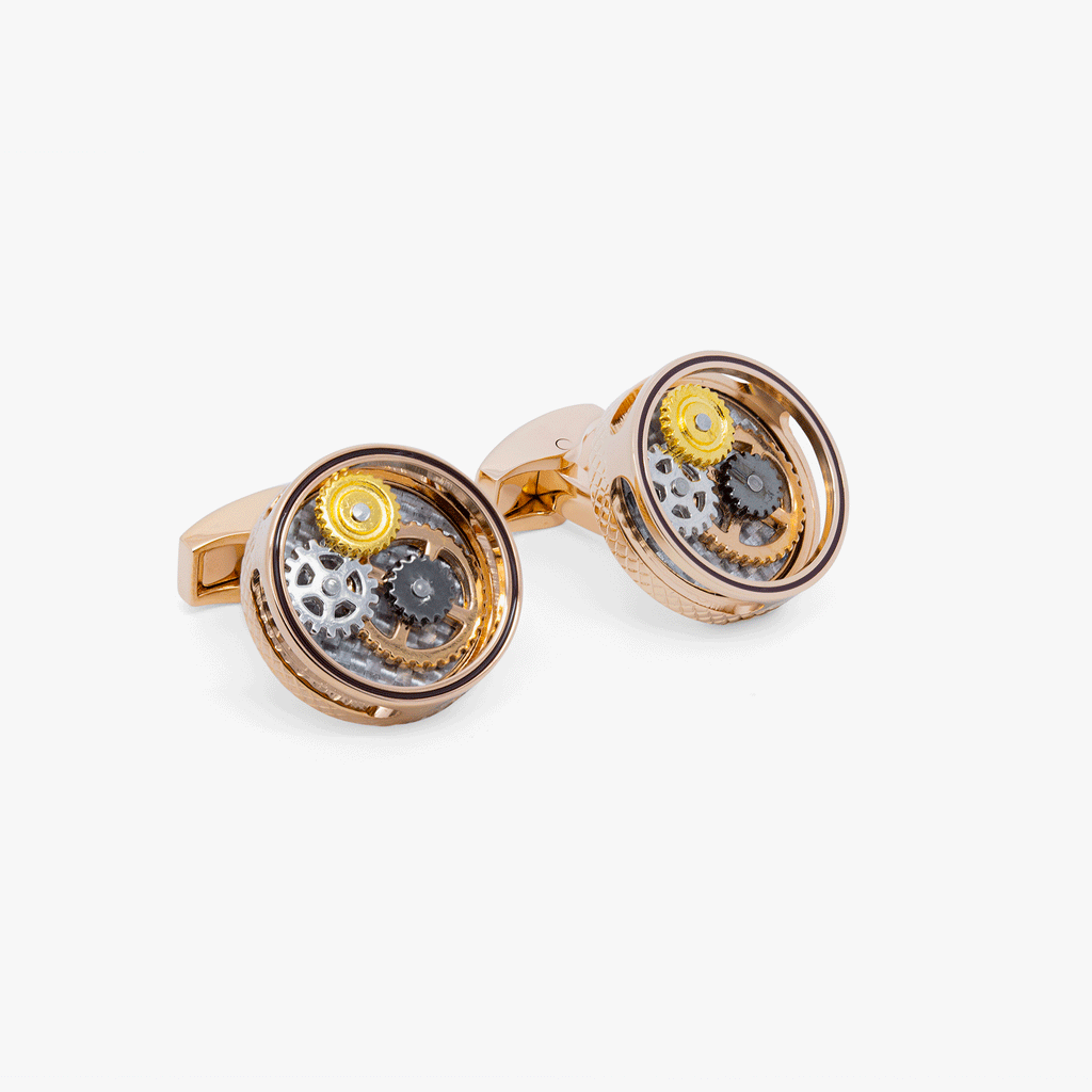 A pair of round gear cufflinks with a rose gold finish and visible mechanical gears inside.