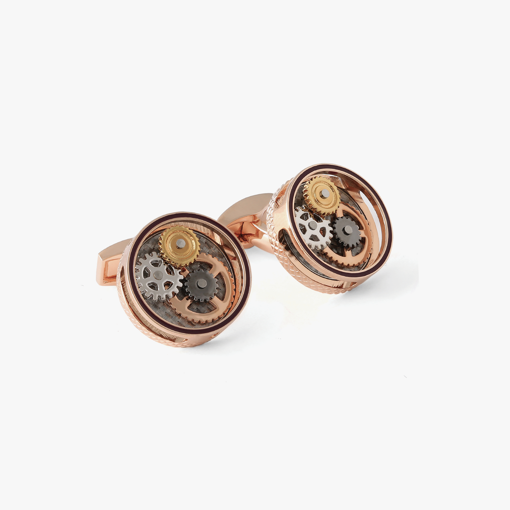 A pair of round gear cufflinks with a rose gold finish and visible mechanical gears inside.