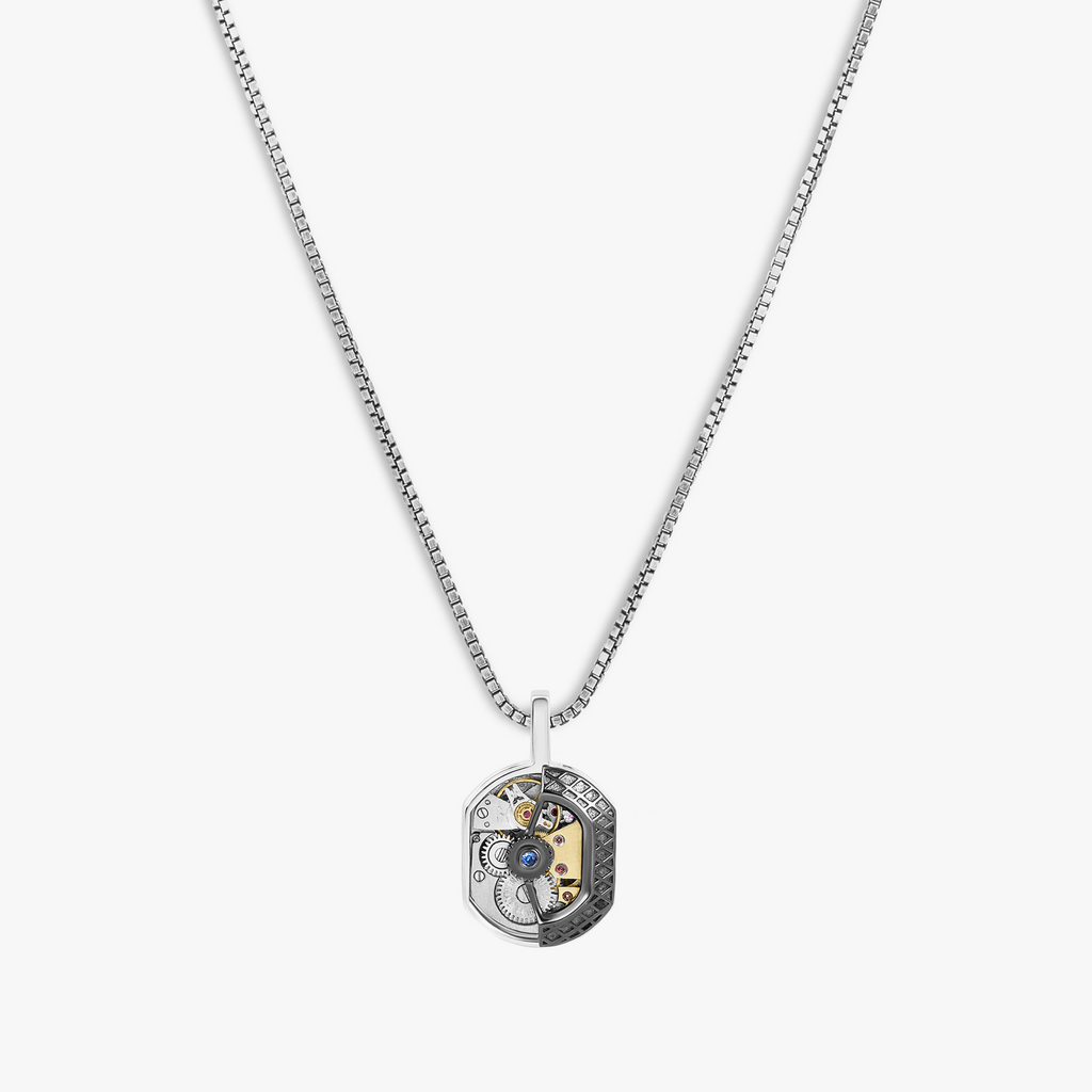 A tonneau skeleton pendant necklace with blue sapphire and rhodium plated silver on a box chain.