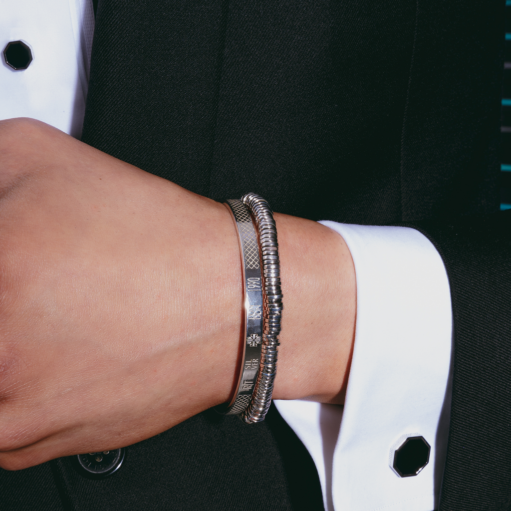 A set of black onyx cufflinks with a London Eye-inspired design, accompanied by matching shirt studs, against a white background.